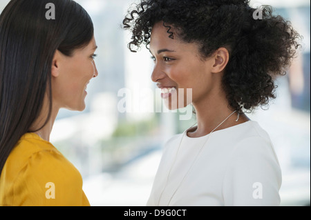 Close-up of two female friends smiling at each other Stock Photo