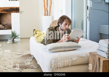 Man using a digital tablet on the bed Stock Photo