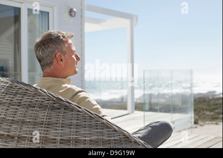Man relaxing in a wicker chair Stock Photo