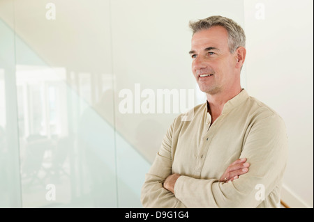 Smiling man standing with his arms crossed Stock Photo