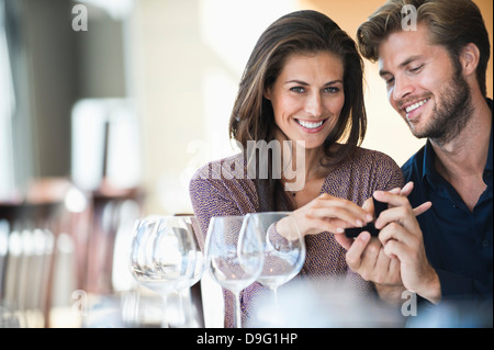 Man giving engagement ring to his girlfriend in a restaurant Stock Photo