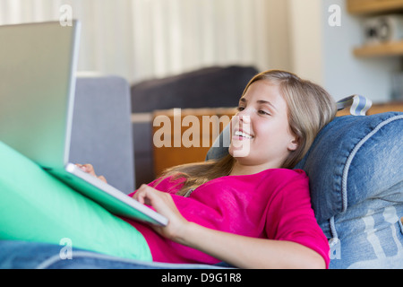 Girl lying on a bean bag and using a digital tablet Stock Photo - Alamy