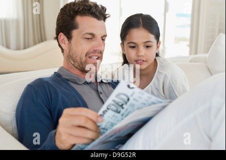 Man and his daughter reading a magazine Stock Photo