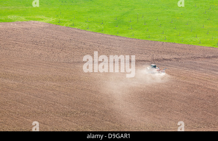 Tractor plowing or ploughing field of soil in dry conditions in southern germany in Neckar valley Stock Photo