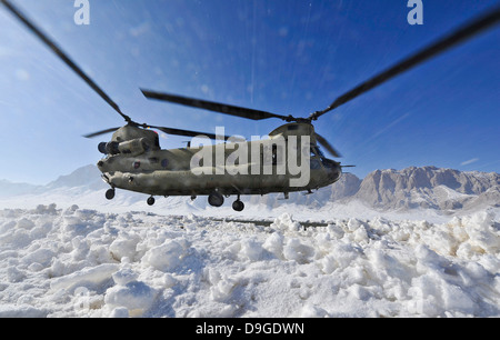 Snow flies up as a U.S. Army CH-47 Chinook helicopter prepares to land Stock Photo