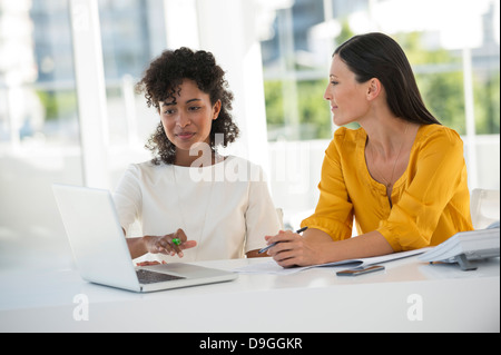 Female friends working on a laptop at home Stock Photo