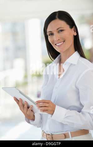 Portrait of a businesswoman using a digital tablet in an office Stock Photo