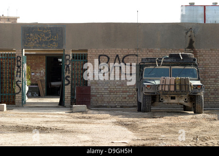 A M998 humvee parked outside an abandoned school. Stock Photo