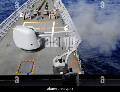 A Mk-45 5-inch .54-caliber gun is fired aboard USS Cowpens. Stock Photo