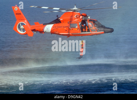 A US Coast Guard rescue swimmer is lowered into the water during training with an aircrew from Coast Guard Air Station Los Angeles November 31, 2012 off the Hermosa Beach Pier, CA. Stock Photo