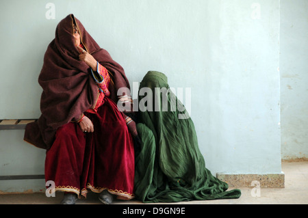 Afghan Women wearing traditional full body covers called Burqua sit in the waiting area outside the female outpatient department of the Moqur Comprehensive Health Clinic Dec. 17, 2009 in Moqur, Afghanistan. Stock Photo