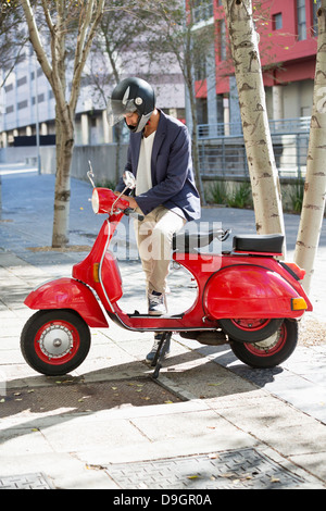 Man standing with a scooter Stock Photo