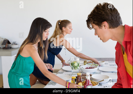 Friends setting a dining table Stock Photo