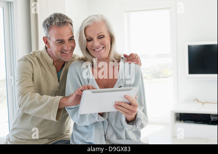 Smiling senior couple using a digital tablet Stock Photo