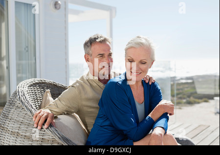 Couple sitting in a wicker chair romancing Stock Photo