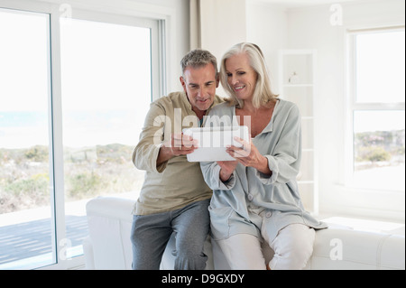 Smiling senior couple using a digital tablet Stock Photo