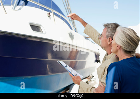 Couple standing near a yacht with a brochure Stock Photo