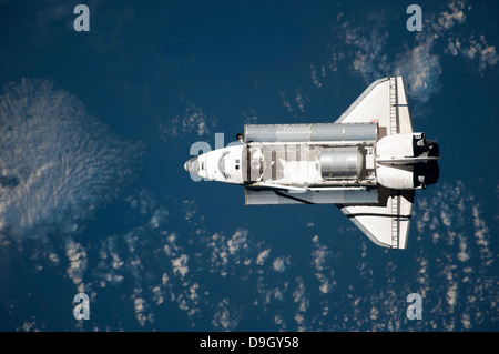 Aerial view of Space Shuttle Discovery over Earth as it approaches the International Space Station. Stock Photo