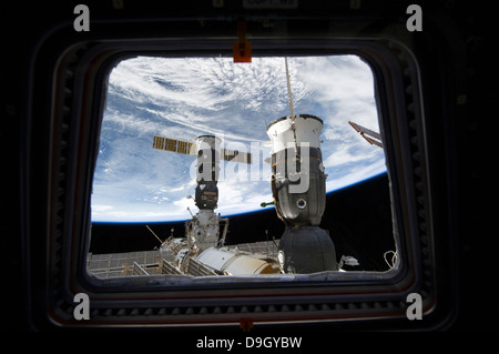 Two Russian spacecraft docked with the International Space Station, as seen from Space Shuttle Discovery's flight deck window. Stock Photo