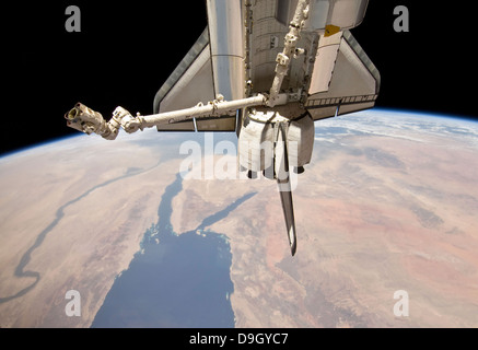 The aft section of the docked space shuttle Discovery and the station's robotic Canadarm2. Stock Photo