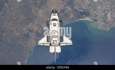 Flying above the Atlantic coast of Spain and the Gulf of Cadiz, the space shuttle Atlantis is approaching to the International S Stock Photo