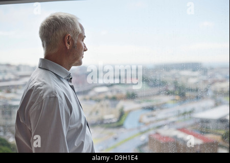 Man looking through a window Stock Photo