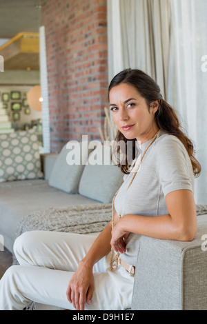 Portrait of a beautiful woman sitting on a couch Stock Photo
