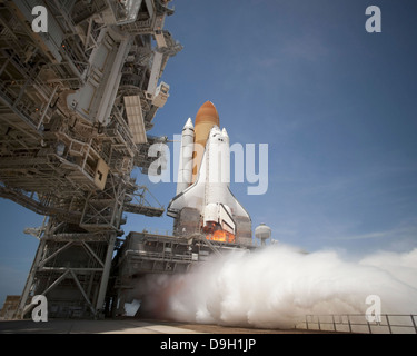 An exhaust plume forms under the mobile launcher platform on Launch Pad 39A as space shuttle Atlantis lifts off into orbit. Stock Photo