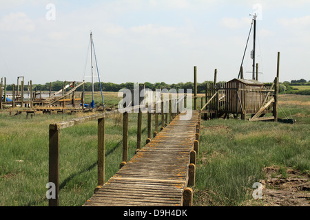 Old wooden jetty and huts at low tide at historic Skippool Creek Thornton Lancashire UK Stock Photo