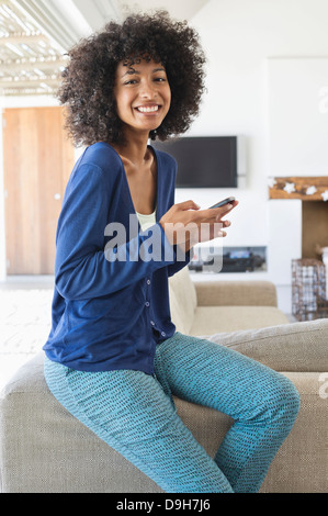 Smiling woman using a mobile phone Stock Photo