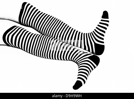 Woman legs in back and white long striped socks isolated on white background Stock Photo