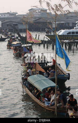 Bintan, Riau Islands, Indonesia. 19th June, 2013. Supporters and competitors stand on boats as they watch the dragon boat festival on June 19, 2013 in Bintan, Riau Islands, Indonesia. Dragon Boat racing dates back over 2,000 years and has now developed into a serious sport on the calendar of many countries around the world. Credit: Credit:  Sijori Images/ZUMAPRESS.com/Alamy Live News Stock Photo