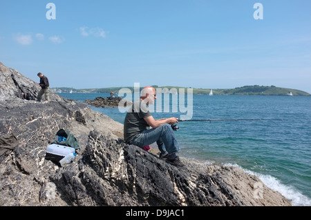 A man fishing from Pendennis Point in Falmouth, Cornwall Stock Photo