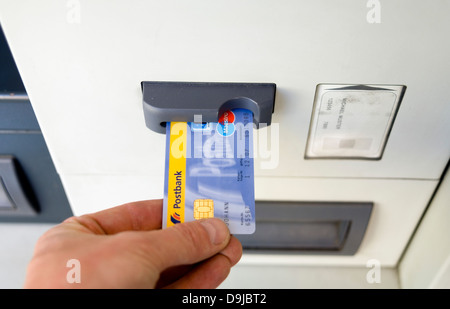 Hand with EC-Card on Bancomat from German Postbank Stock Photo