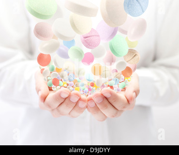 Colorful pills falling into open palms Stock Photo