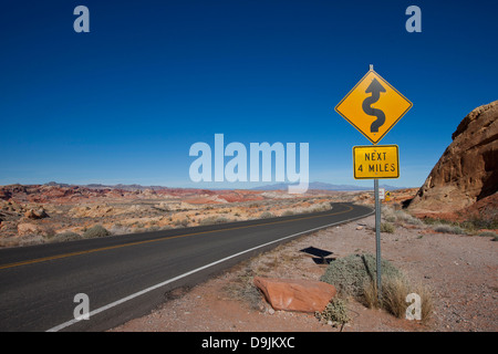 Curves ahead road sign next 4 miles at Rainbow Vista, Valley of Fire Road, Valley of Fire State Park, Nevada, United States of America Stock Photo