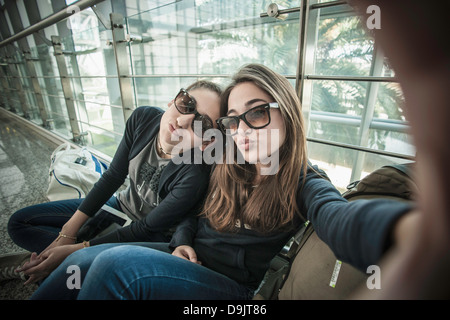 Two teenage girls posing to camera, photographing themselves Stock Photo