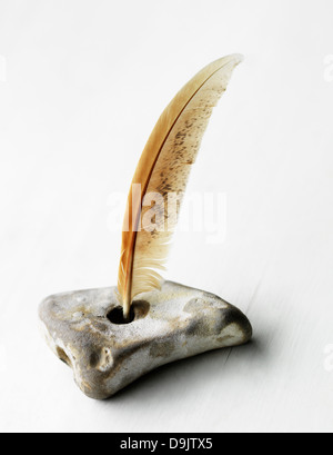 Feather quill in stone inkwell Stock Photo