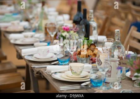 A large table set for a meal using a vintage theme. Stock Photo
