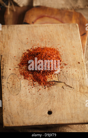 red hot chillies pepper flakes on wooden board background, shallow dof Stock Photo