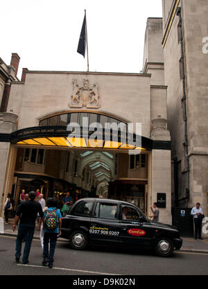 Iconic black cab in front of the Burlington Arcade, a covered shopping arcade that runs behind Bond Street from Piccadilly through to Burlington Gardens, London, England, United Kingdom Stock Photo