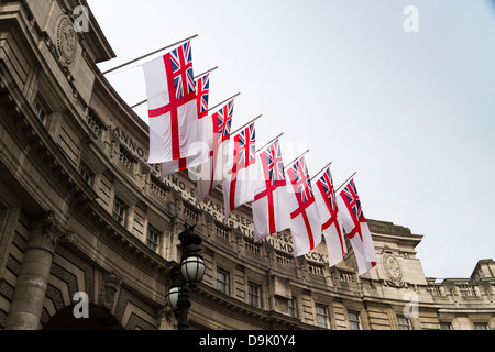 White ensign flags of the Royal Navy adorn Admiralty Arch, Whitehall, London, UK Stock Photo