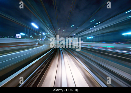 Motion blur of a city and tunnel from inside a moving monorail in Tokyo. Stock Photo