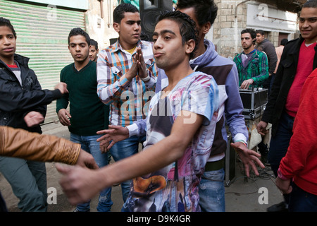 Boys and youth dance to a sound system in the streets to celebrate a wedding, Islamic Cairo, Cairo, Egypt Stock Photo