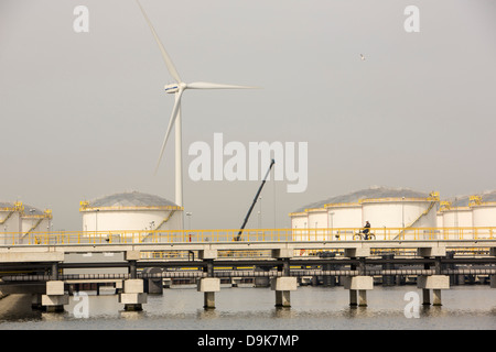 Climate change heaven and hell, oil storage tanks and wind turbines on the docks in Amsterdam, Netherlands. Stock Photo