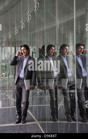 Reflection of a businessman talking on a mobile phone Stock Photo