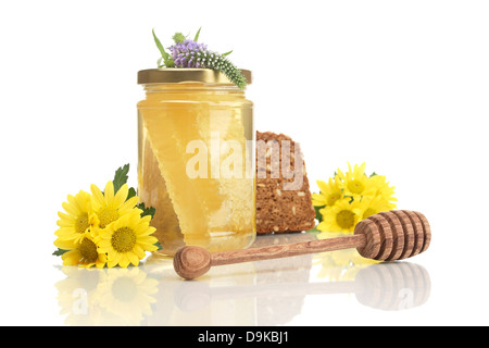 Comb honey with wholemeal bread, honey spoon and flowers, Comb honey with wholemeal bread, honey and flowers spoon Stock Photo