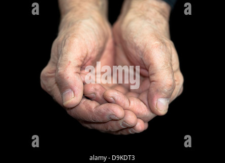 Poverty. Old hands on black with clipping path Stock Photo