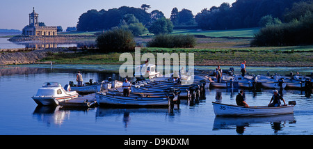 Fisherman in their boats preparing for a fishing trip, on Rutland Water, England, UK, with Normanton Church in the background. Stock Photo