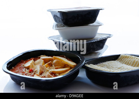 A tub of cottage pie and chili chips with a stack of unopened frozen food in the background Stock Photo